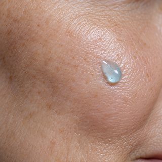 Pele com aspecto firme e uma gota do sérum azul